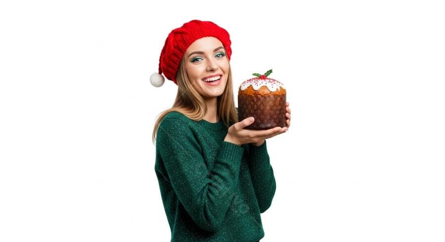 Mulher jovem loira sorrindo com gorro vermelho segurando panetone de Natal festivo