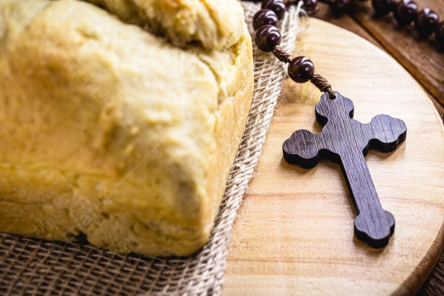 Pão caseiro e rosário de madeira sobre mesa rústica celebração religiosa