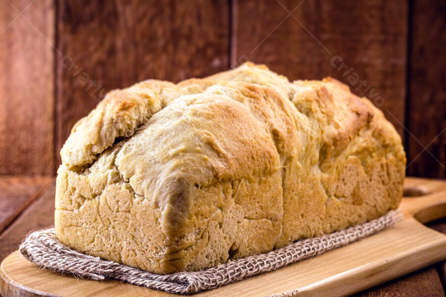 Pão caseiro dourado assado fresco em tábua de madeira rústica