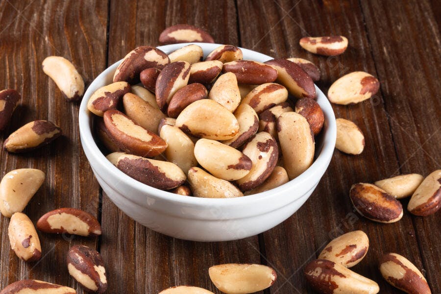 Castanhas-do-pará em tigela branca sobre mesa de madeira rústica marrom e creme