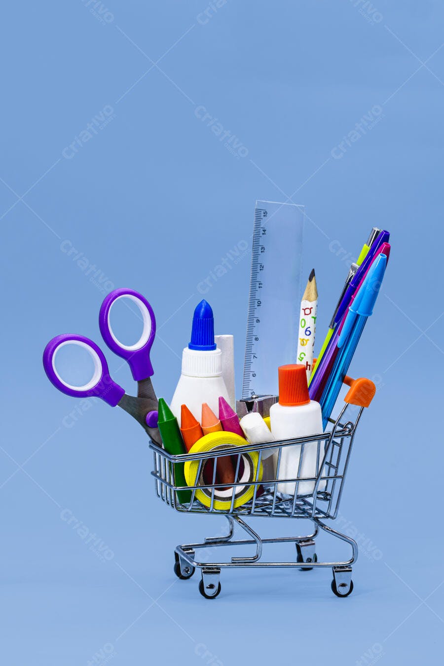 Materiais escolares coloridos em mini carrinho de compras com fundo azul