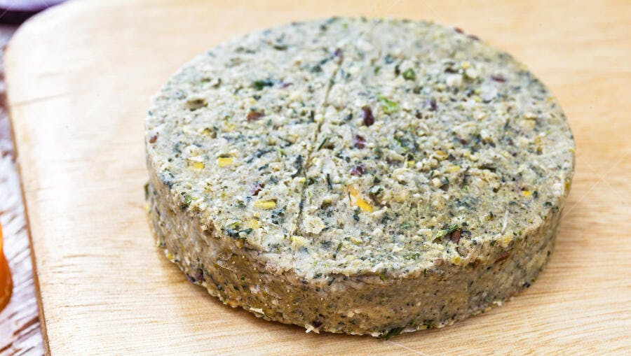 Hambúrguer de legumes cru verde em tábua de madeira clara para veganos
