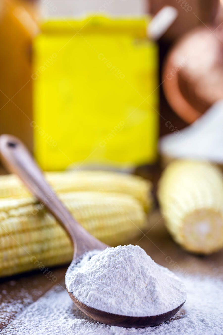 Colher de pau com farinha branca milho fresco desfocado