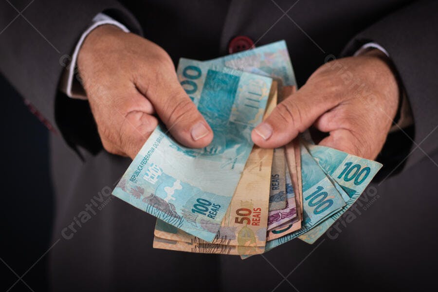 Mãos de homem adulto segurando notas de Reais brasileiros negócio e finanças