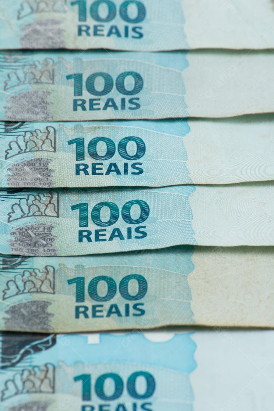 Cédulas de 100 Reais dinheiro brasileiro azul empilhado em close-up