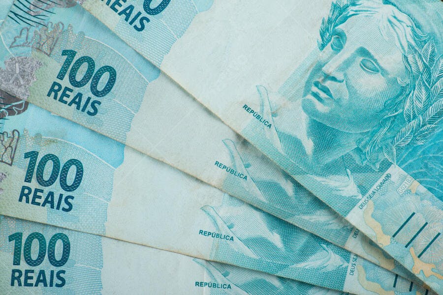 Notas de 100 Reais brasileiras azuis empilhadas close-up financeira