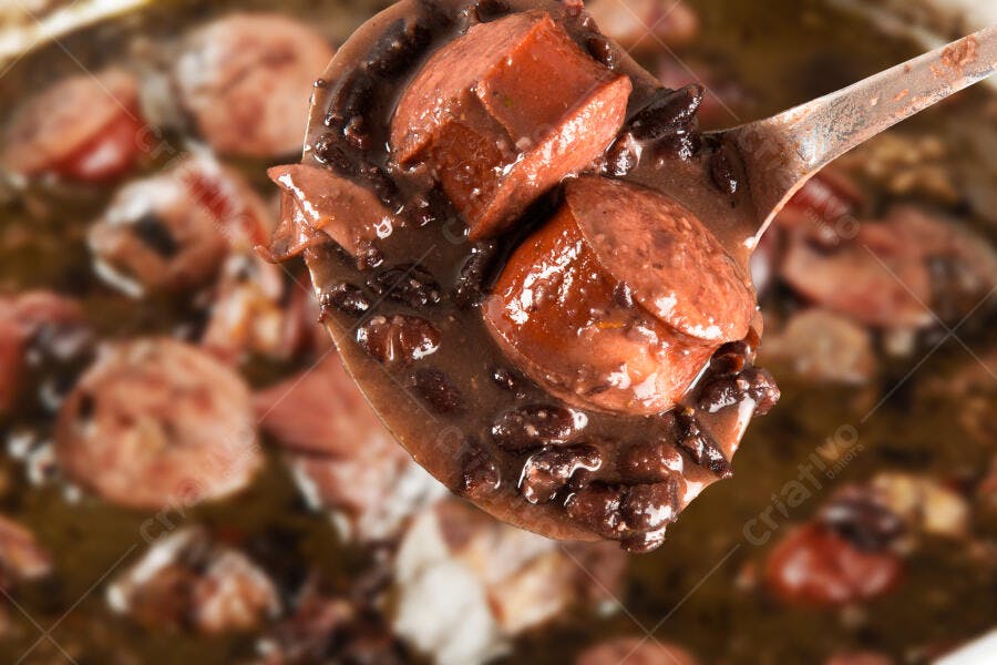 Feijoada brasileira com linguiça e feijão preto em colher