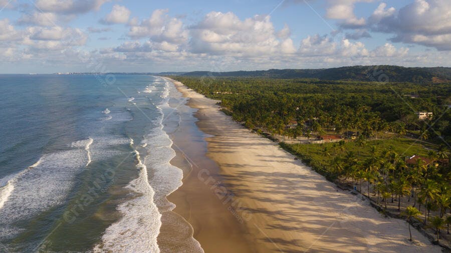 Praia tropical longa com areia dourada e mar azul oceano sob céu claro