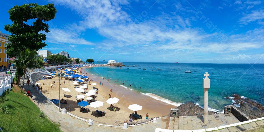 Praia Porto da Barra Salvador Bahia mar azul pessoas guarda-sóis brancos e azuis