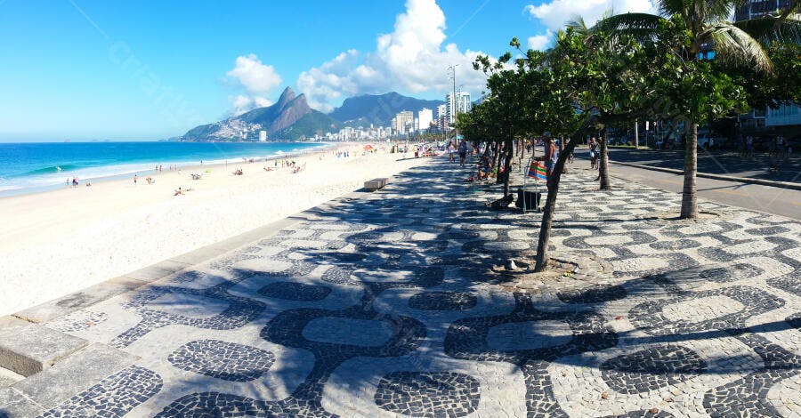 Praia de Ipanema Rio de Janeiro calçadão com palmeiras e montanha Dois Irmãos céu azul