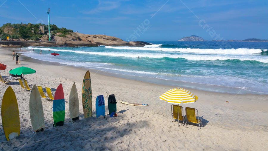 Pranchas de surfe coloridas na praia com areia clara e mar azul em dia ensolarado