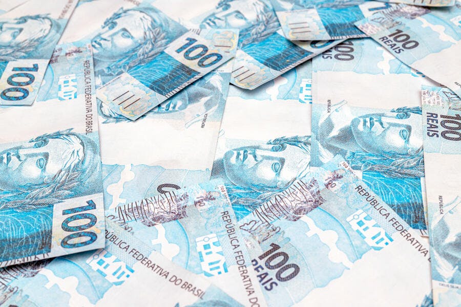 Notas de cem reais azuis espalhadas dinheiro brasileiro em abundância