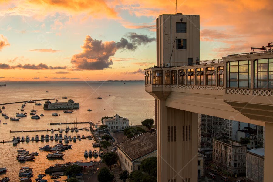 Elevador Lacerda Salvador ao por do sol com céu laranja e barcos na baía