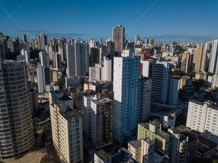 Vista aérea de cidade com arranha-céus e edifícios modernos sob céu azul claro