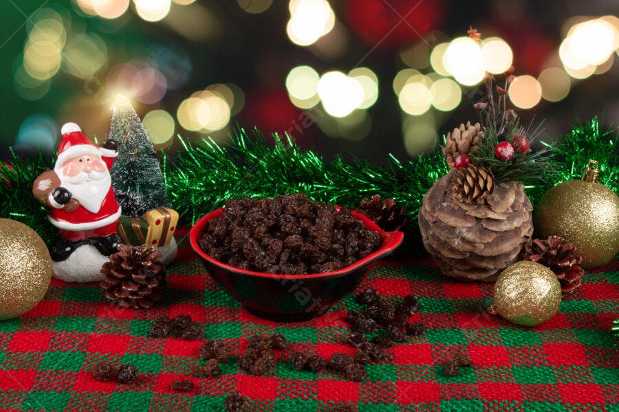 Tigela de passas de uva com decoração natalina Papai Noel bolas douradas e pinhas