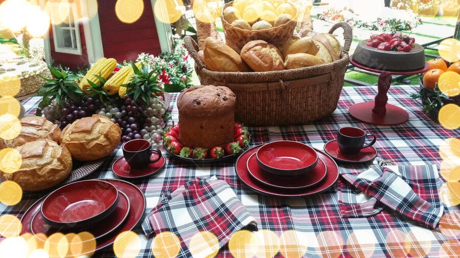 Mesa festiva com pães panetone frutas e louça vermelha natalina aconchegante