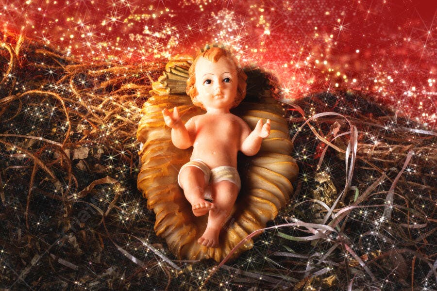 Bebê Jesus no presépio natalino com brilhos dourados e vermelhos