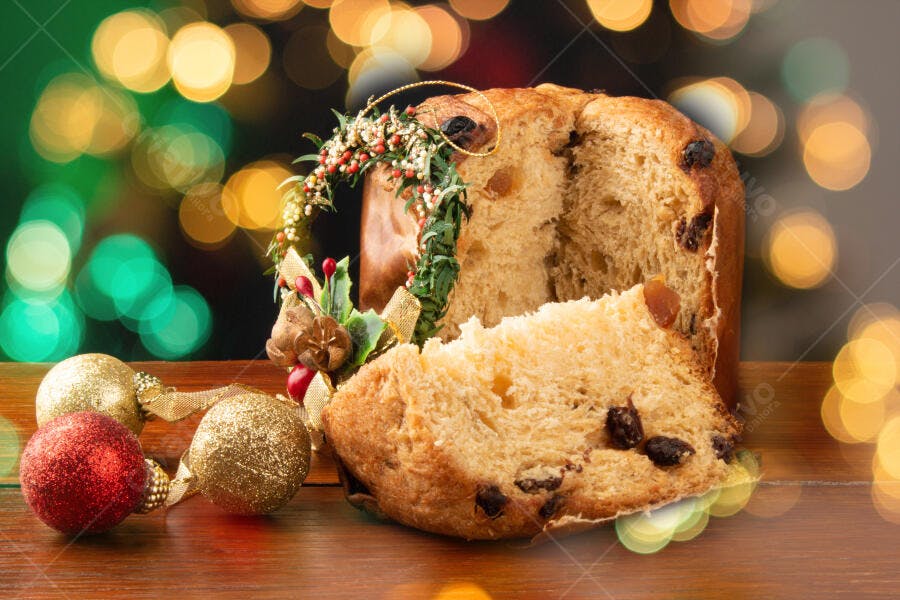 Panettone fatiado decorado para o Natal com bolas douradas e luzes bokeh