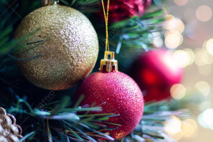Enfeites de Natal dourado e vermelho brilhante na árvore com luzes bokeh festivas