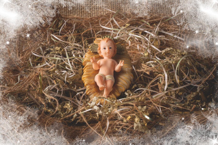 Bebê Jesus estatueta em manjedoura de palha no Natal com moldura de neve