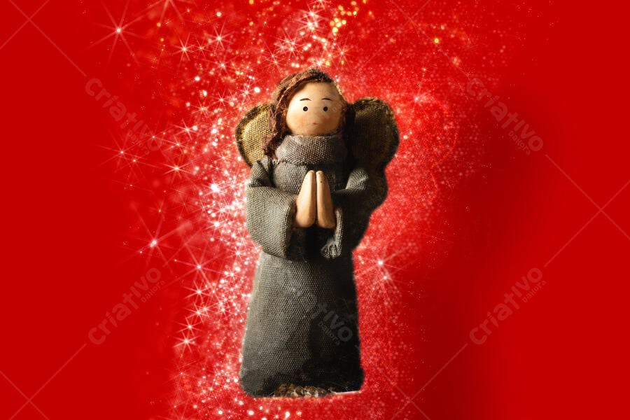 Anjo artesanal de madeira e tecido cinza em fundo vermelho cintilante