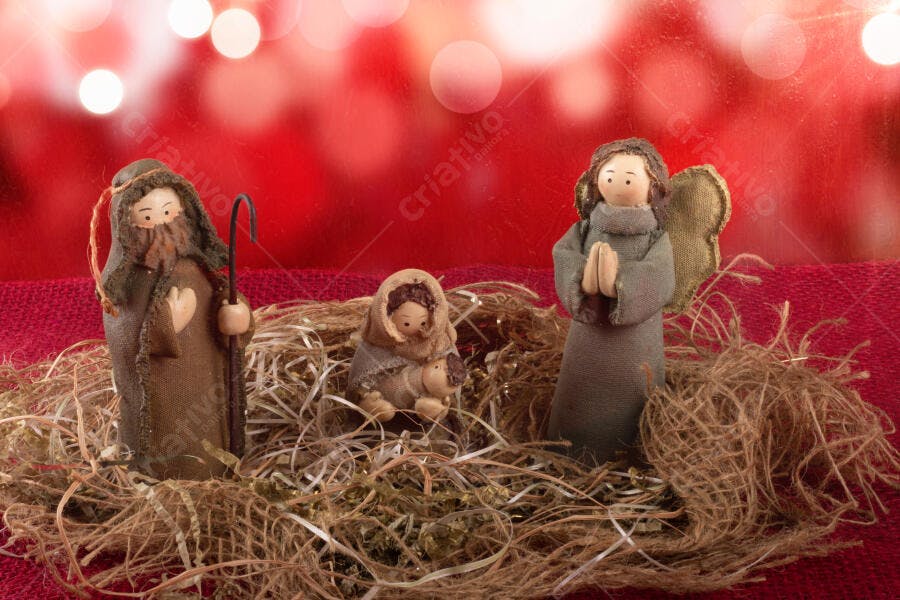 Presépio de Natal artesanal com Maria Jose e Jesus em fundo vermelho bokeh