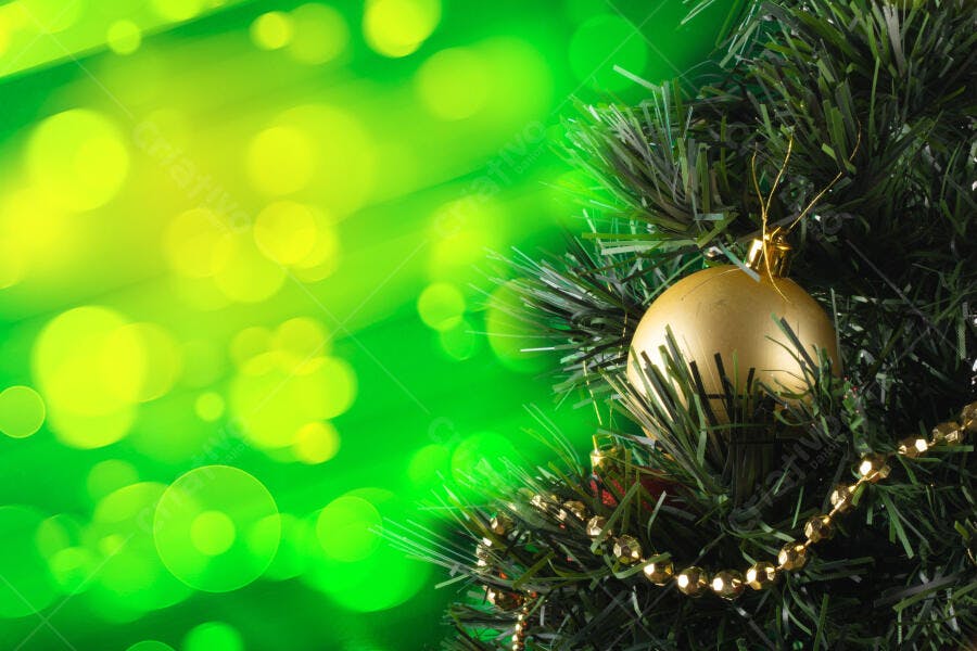 Árvore de Natal verde com bola dourada e bokeh brilhante festivo