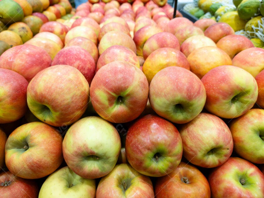 Maçãs frescas vermelhas e amarelas em exibição no supermercado