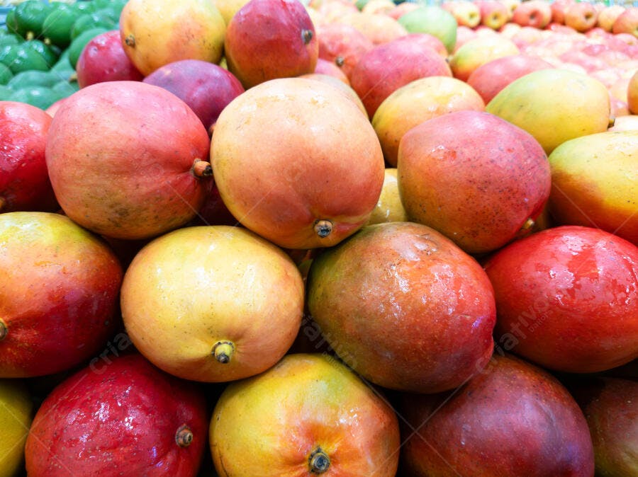 Mangas vermelhas e amarelas frescas em mercado de frutas vibrante