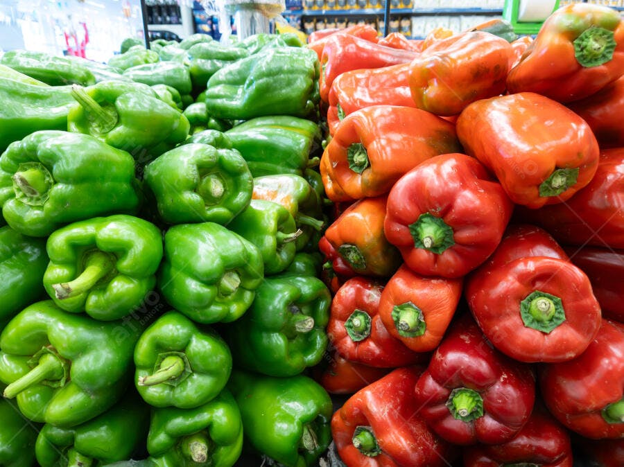 Pimentões verdes e vermelhos frescos em exposição no supermercado