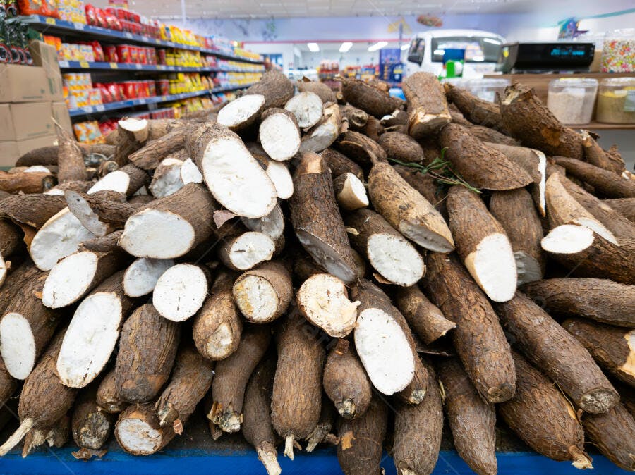 Mandioca fresca crua e cortada em pilha no mercado
