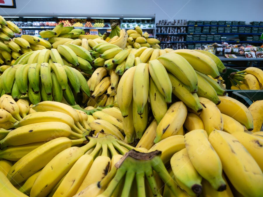 Pilha de bananas maduras e verdes frescas em supermercado