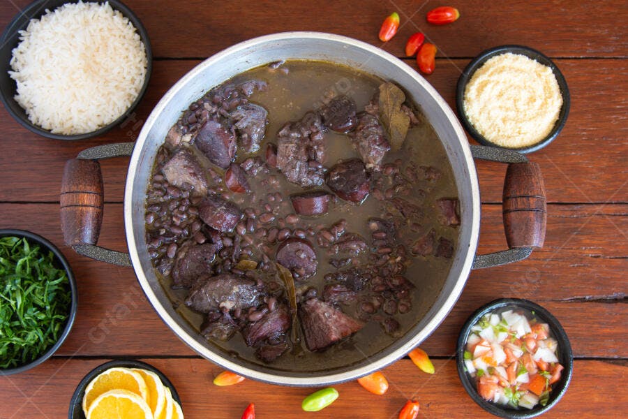 Feijoada brasileira completa com arroz, farofa e couve em mesa de madeira
