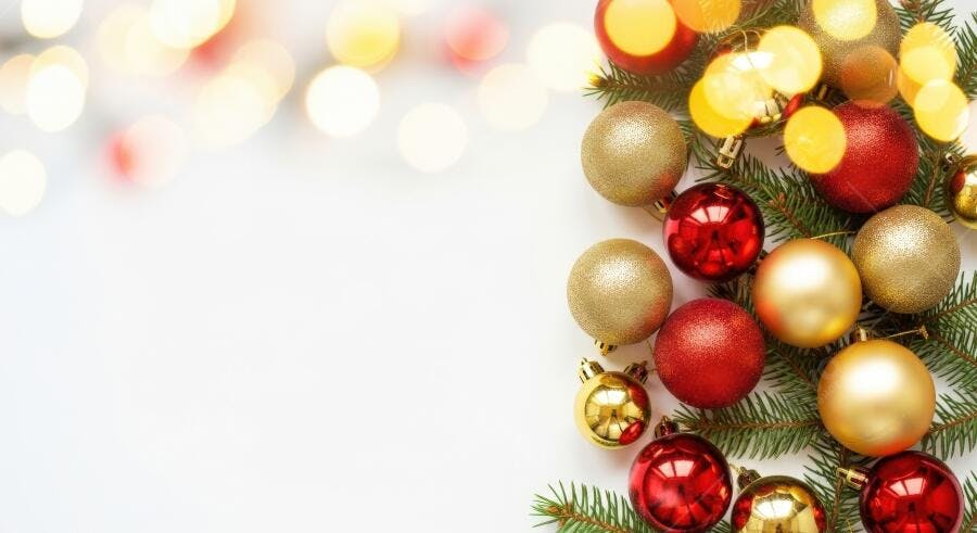 Bolas de Natal vermelhas e douradas com pinho e luzes bokeh festivas