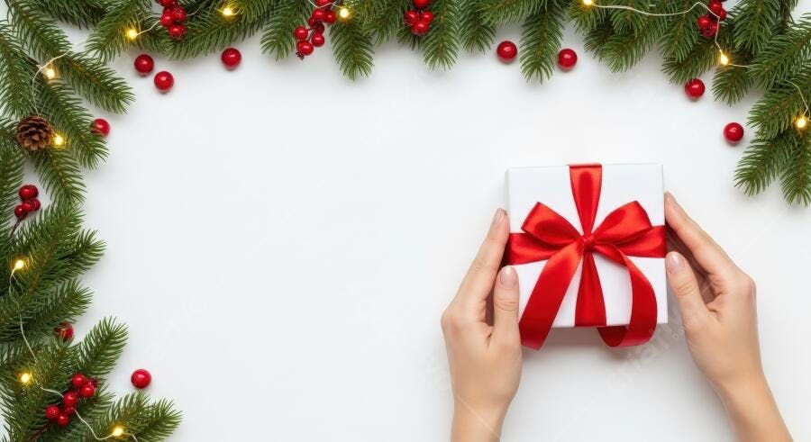 Mãos segurando presente de Natal branco com laço vermelho em fundo festivo