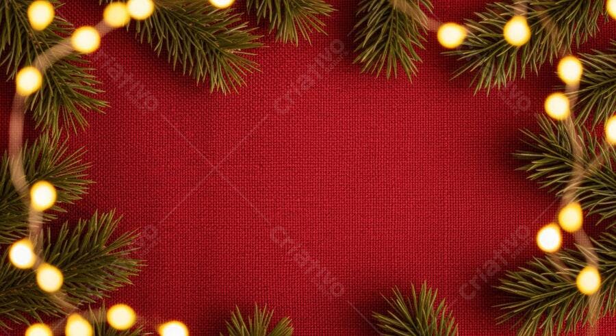 Moldura natalina de pinho e luzes douradas em fundo vermelho textura