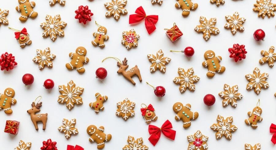 Biscoitos de gengibre enfeites vermelhos espalhados fundo branco Natal