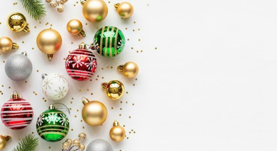 Bolas de Natal douradas vermelhas verdes e prateadas em fundo branco festivo