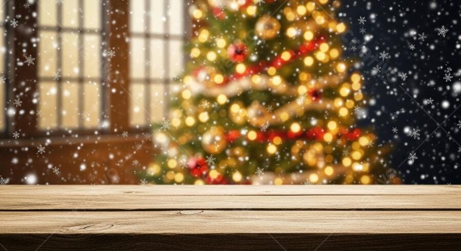 Mesa de madeira com árvore de Natal iluminada e flocos de neve caindo