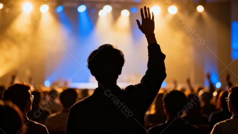 Homem de silhueta com mão levantada em evento com luzes azuis e laranjas