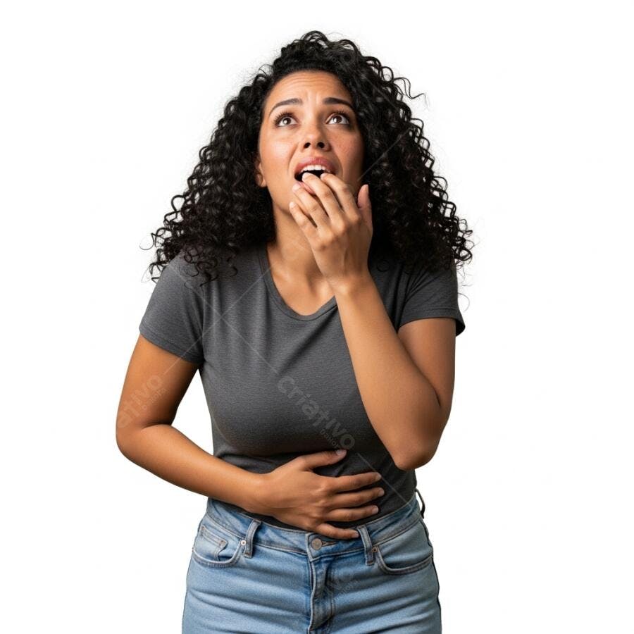 Mulher de cabelo cacheado camiseta cinza e jeans azul surpresa com dor abdominal
