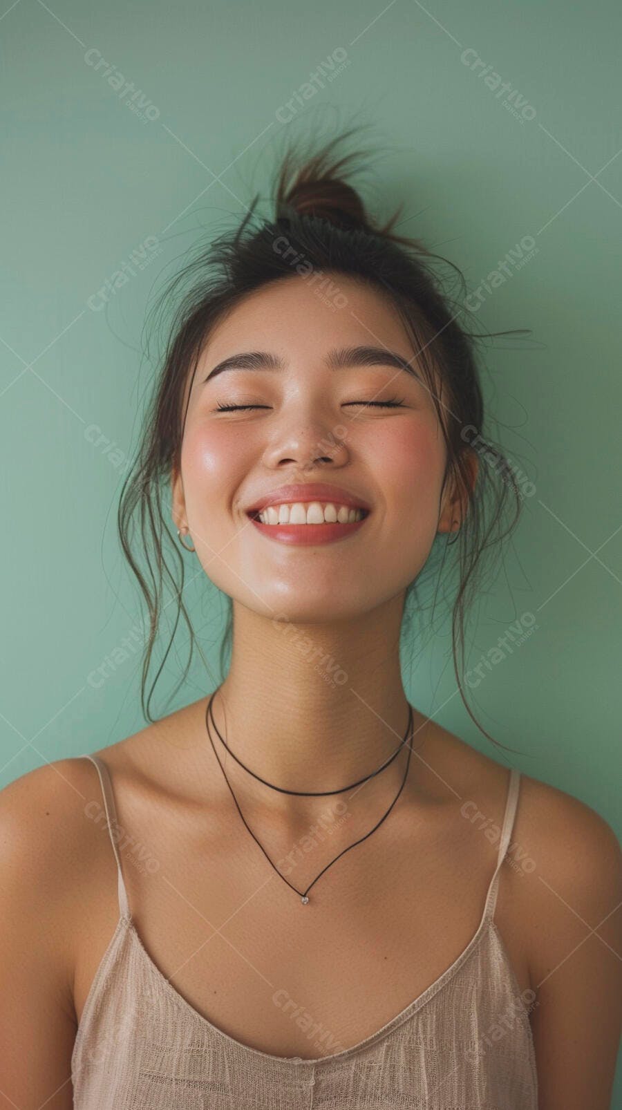 Mulher asiática feliz de olhos fechados sorrindo em fundo verde menta