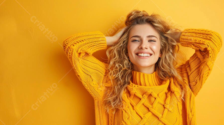 Mulher jovem loira sorrindo e feliz com suéter amarelo vibrante