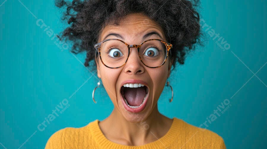 Mulher negra de óculos surpresa gritando com suéter amarelo em fundo azul