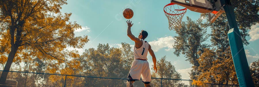 Jovem atleta masculino jogando basquete em quadra ao ar livre no outono