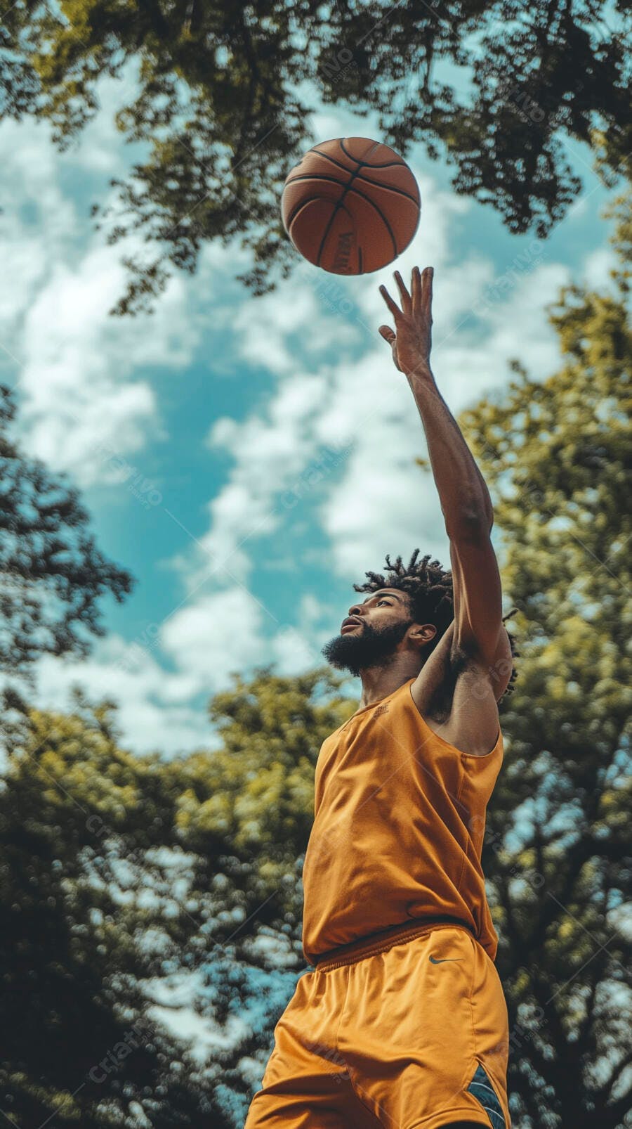 Jovem atleta negro arremessando bola de basquete sob céu azul e árvores