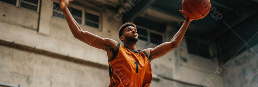 Homem negro jogando basquete com camisa laranja pulando na quadra