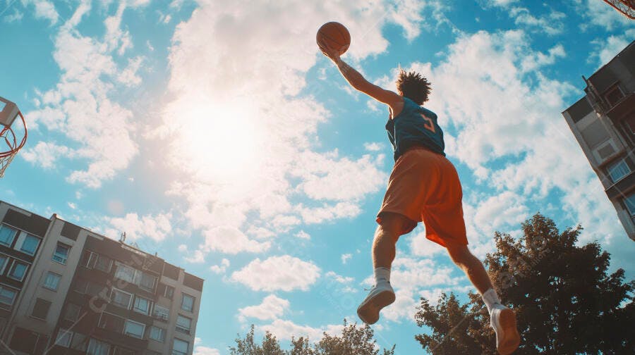 Homem atlético pulando em quadra de basquete azul celeste ensolarado