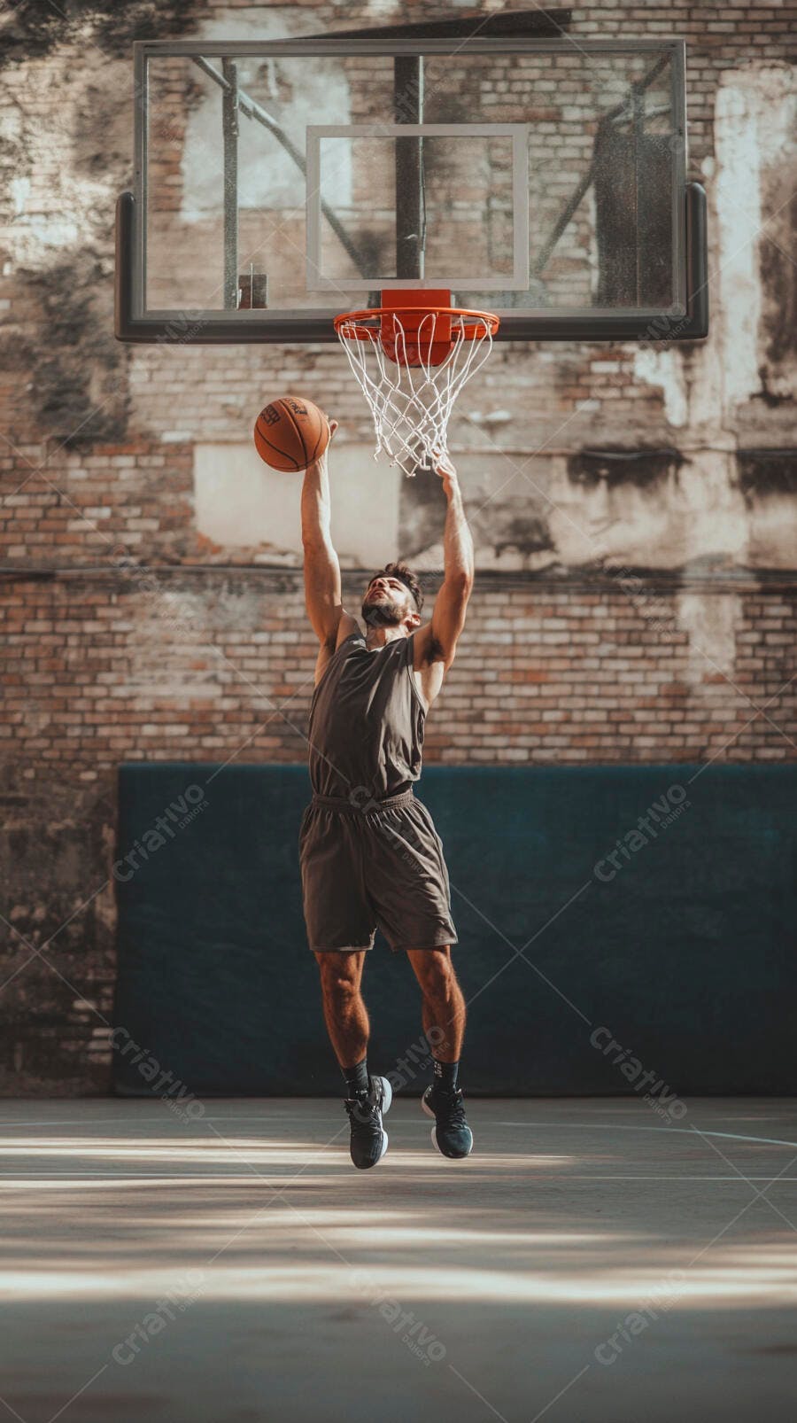 Homem atlético pulando para enterrar cesta de basquete em quadra urbana
