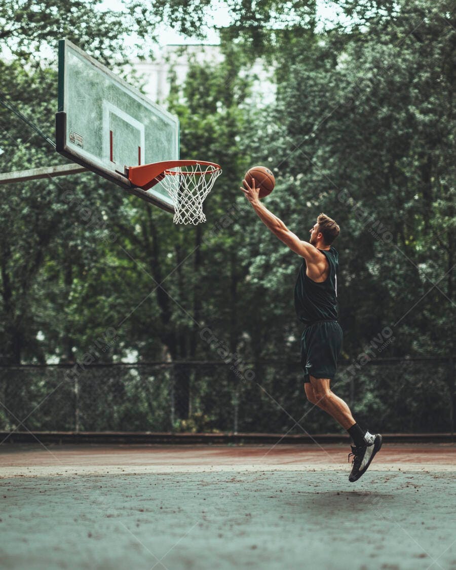 Homem caucasiano atlético enterrando bola de basquete em quadra verde ao ar livre